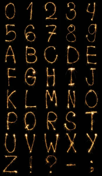 Vue rapprochée de l'alphabet anglais clair et des chiffres sur fond noir — Photo de stock