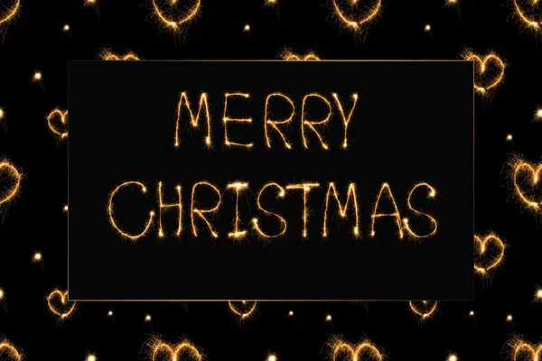 Close up view of merry christmas light lettering and hearts light signs on black background — Stock Photo