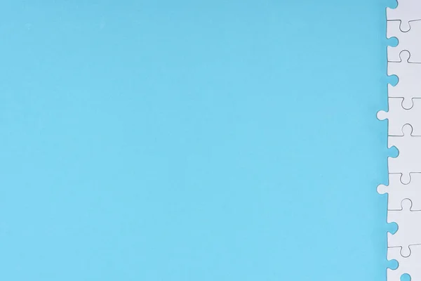 Вид зверху на білі шматочки головоломки, розташовані на синьому фоні — стокове фото