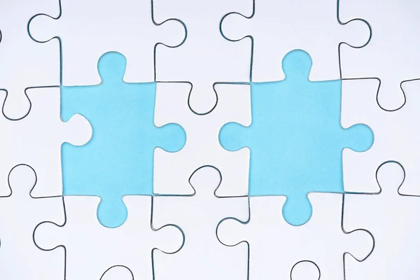 Flat lay with white puzzle pieces on blue background — Stock Photo