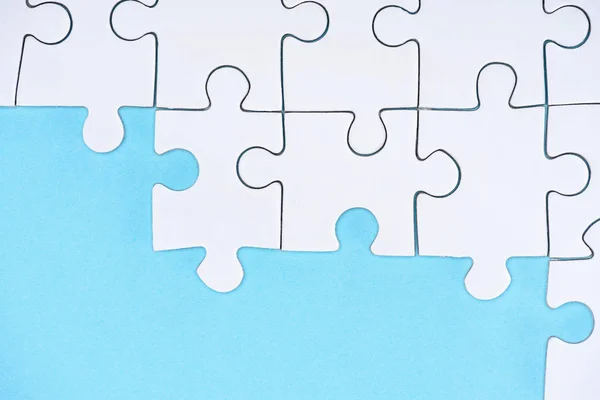 Ansicht der weißen Puzzles Anordnung auf blauem Hintergrund — Stockfoto