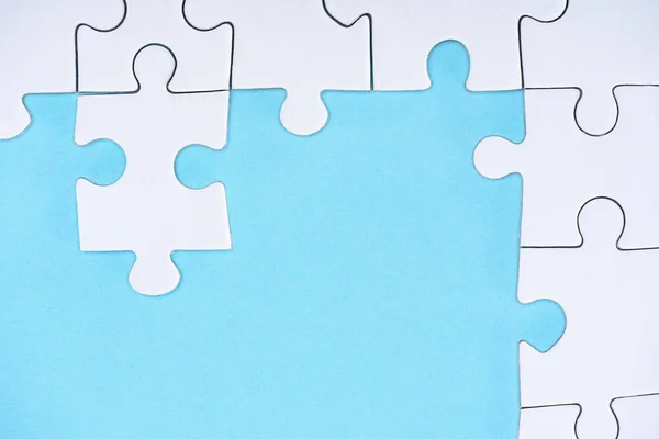 Top view of white puzzles arrangement on blue background — Stock Photo