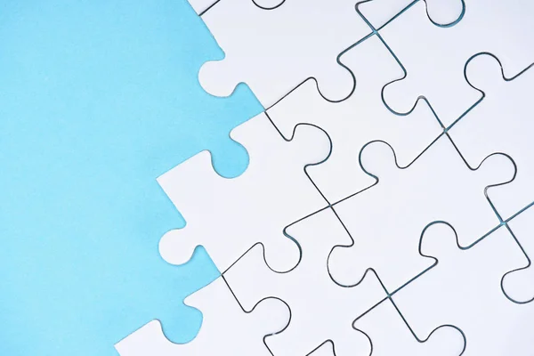 Top view of white puzzles arrangement on blue background — Stock Photo