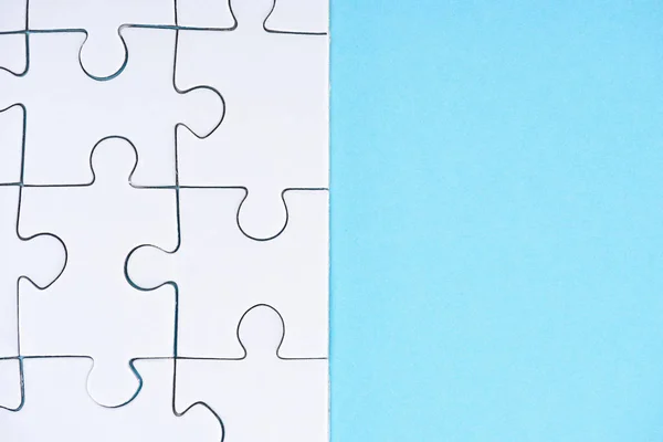 Full frame of white puzzles arrangement on blue backdrop — Stock Photo