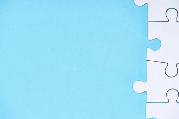 Full frame of white puzzles arrangement on blue backdrop — Stock Photo