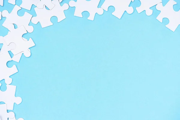 Full frame of white puzzles arrangement on blue backdrop — Stock Photo