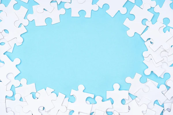 Vollständiger Rahmen aus weißen Puzzles auf blauem Hintergrund — Stockfoto