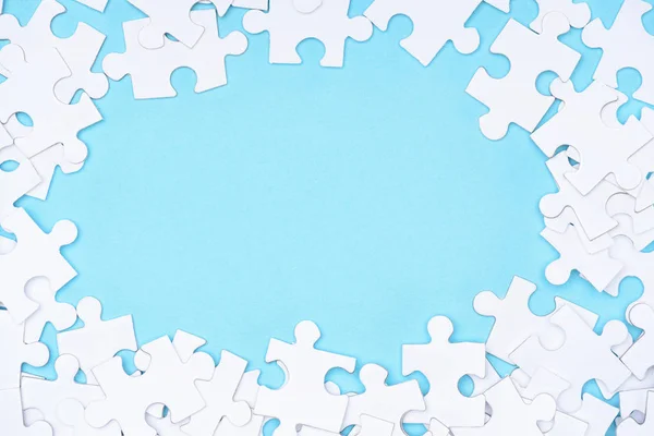 Full frame of white puzzles arrangement on blue backdrop — Stock Photo