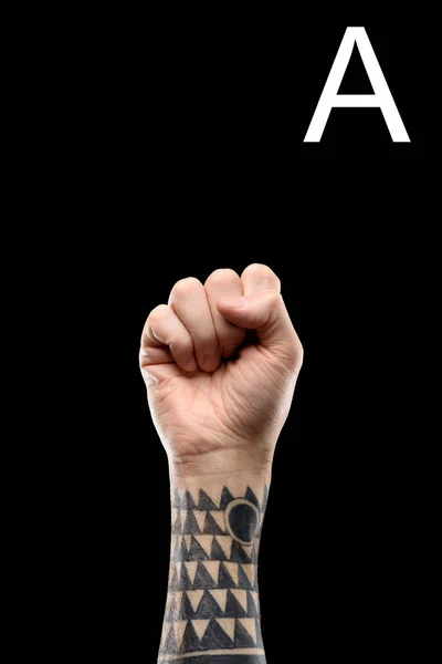 Deaf and dumb language with tattooed male hand and cyrillic letter, isolated on black — Stock Photo