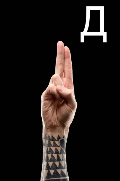 Langage sourd-muet avec main masculine tatouée et lettre cyrillique, isolé sur noir — Photo de stock