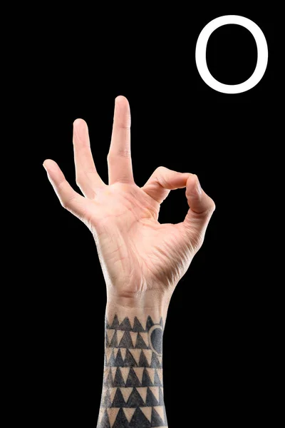 Teilansicht tätowierter männlicher Hand mit kyrillischen Buchstaben, taubstummer Sprache, isoliert auf schwarz — Stockfoto