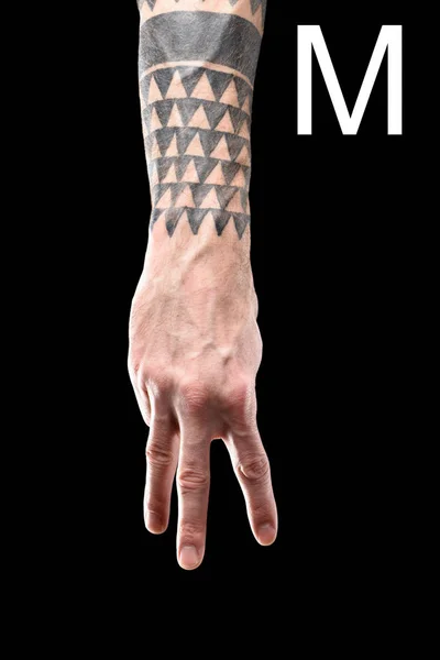 Partial view of tattooed hand showing cyrillic letter, deaf and dumb language, isolated on black — Stock Photo