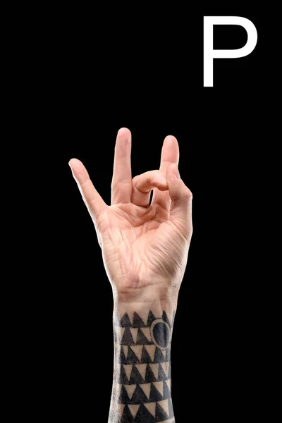 Cropped view of tattooed hand showing cyrillic letter, deaf and dumb language, isolated on black — Stock Photo