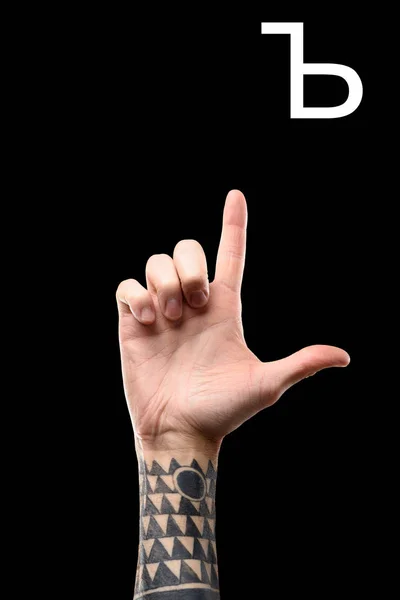 Maschio tatuato mano mostrando lettera cirillica, linguaggio dei segni, isolato su nero — Foto stock