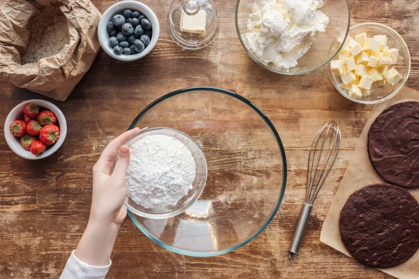 Tiro cortado de mulher segurando farinha e preparando massa para delicioso bolo caseiro — Fotografia de Stock