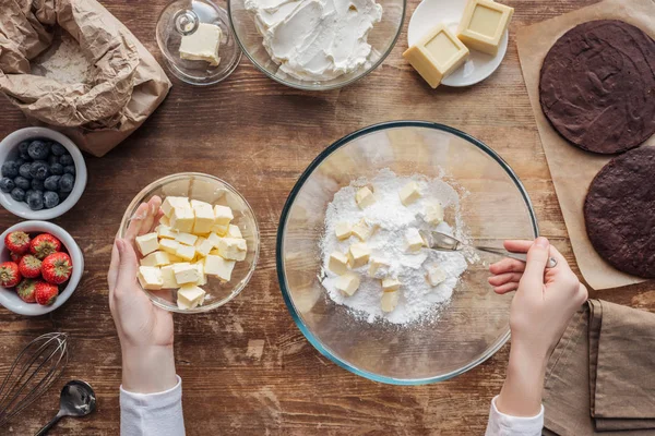 Vue du dessus de la femme mélangeant les ingrédients et préparant la pâte pour gâteau fait maison — Photo de stock