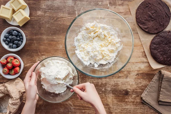 Vista dall'alto parziale della donna che prepara pasta e crema per deliziose torte — Foto stock