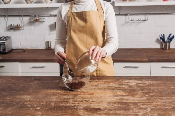 Seção meio da mulher no avental misturando ingredientes e preparando delicioso bolo doce — Fotografia de Stock