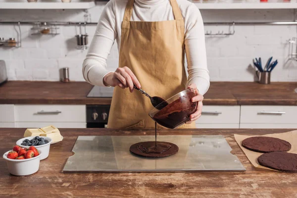 Cropped shot of woman in apron preparing dough for gourmet homemade cake in kitchen — Stock Photo