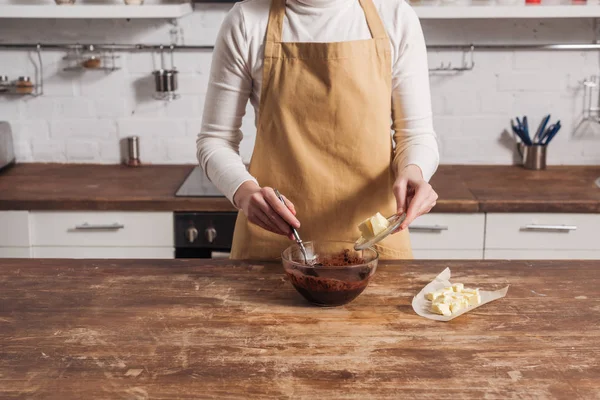 Tiro cortado de mulher em avental preparando massa para delicioso bolo na cozinha — Fotografia de Stock