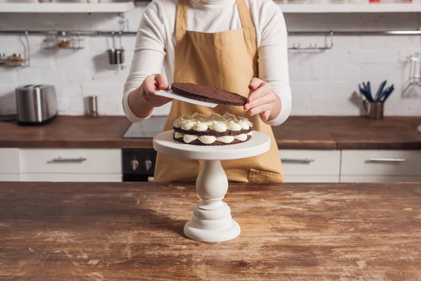 Mid section of woman in apron preparing delicious whoopie pie cake in kitchen — Stock Photo