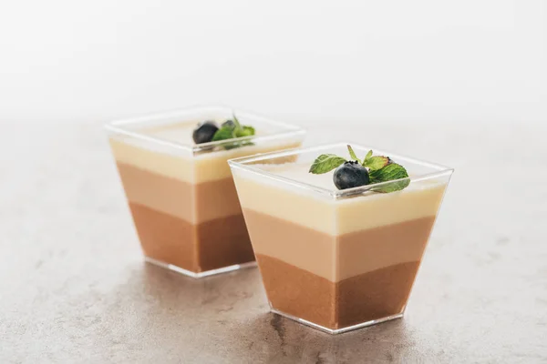 Vue rapprochée de délicieux desserts en mousse triple chocolat dans des verres — Photo de stock