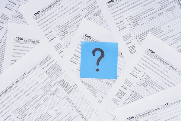 Top view of question mark on blue card with tax forms on background — Stock Photo