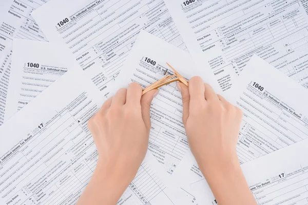 Cropped view of stressed woman breaking pencil with tax forms on background — Stock Photo