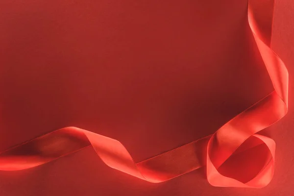 Вид зверху на червону святкову стрічку ізольовану на червоному, концепція дня Святого Валентина — стокове фото