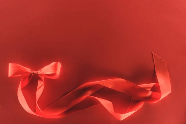 Vista elevada de lazo de cinta festiva roja en rojo, concepto de día de San Valentín - foto de stock