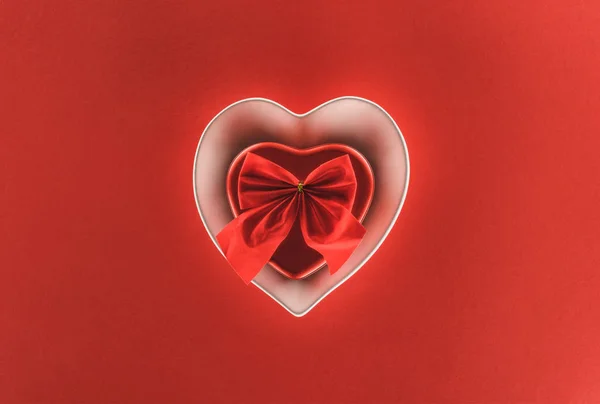 Вид зверху на подарункову коробку у формі серця та святкову стрічку ізольовано на червоному, концепція дня Святого Валентина — стокове фото