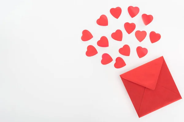 Vista elevada de los símbolos del corazón y la envoltura roja aislada en blanco, San Valentín concepto de día - foto de stock