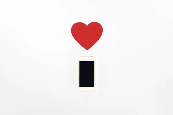 Vue d'en haut du symbole coeur rouge et smartphone avec écran blanc isolé sur blanc, concept St Valentin — Photo de stock