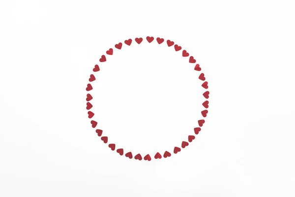 Vista elevada del círculo hecho de símbolos rojos del corazón aislados en blanco, San Valentín concepto de día - foto de stock