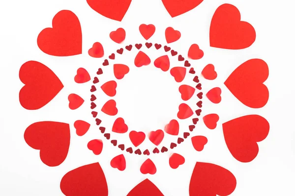 Vista elevada de círculos hechos de símbolos rojos del corazón aislados en blanco, San Valentín concepto de día - foto de stock