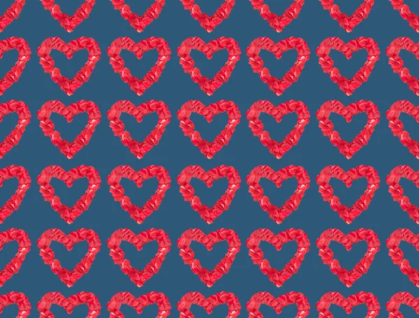 Безшовний візерунок з красивих декоративних червоних сердець на синьому фоні — стокове фото