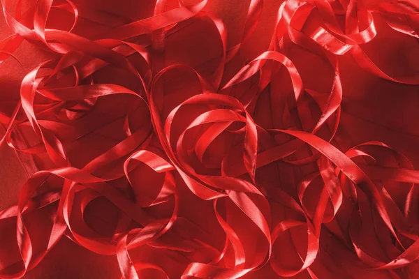 Vista superior de cintas decorativas sobre fondo rojo, concepto de día de San Valentín - foto de stock