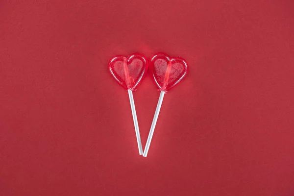 Due lecca-lecca a forma di cuore su sfondo rosso, concetto di giorno di San Valentino — Foto stock