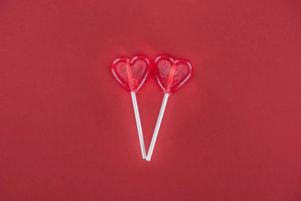 Two heart shaped lollipops on red background, valentines day concept — Stock Photo