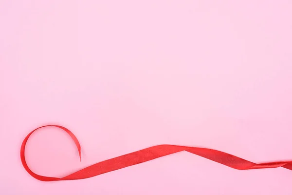 Hermosa cinta roja decorativa sobre fondo rosa, concepto de día de San Valentín - foto de stock