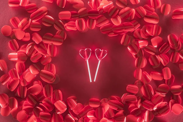 Deux bonbons en forme de coeur et de beaux pétales rouges, concept de Saint Valentin — Photo de stock