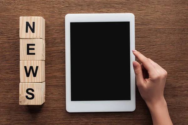 Imagem recortada de jornalista usando tablet com tela em branco, cubos de madeira com notícias palavra sobre mesa de madeira — Fotografia de Stock
