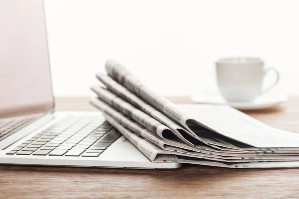 Ноутбук, каву і стопки газет на дерев'яні настільні — стокове фото