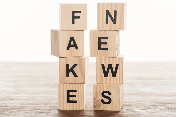 Cubos de madeira com palavras notícias falsas na mesa de madeira — Fotografia de Stock