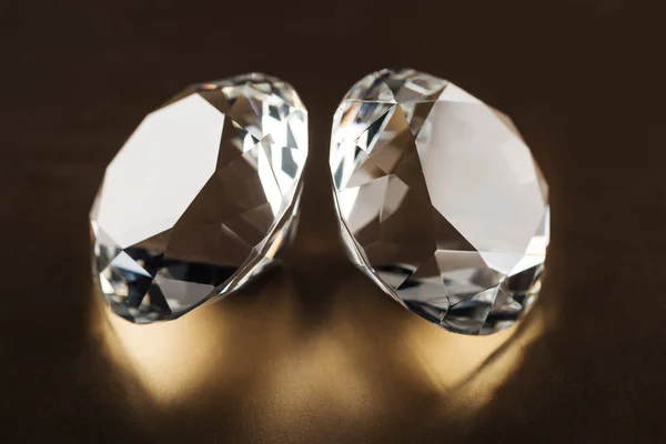 Close-up de diamantes claros sobre fundo escuro dourado — Fotografia de Stock
