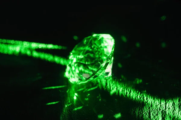 Diamante puro com raios de néon verde brilhante no fundo escuro — Fotografia de Stock