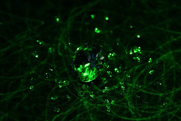 Diamantes grandes e pequenos com luz de néon verde brilhante no fundo escuro — Fotografia de Stock