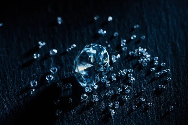 Diamantes grandes y pequeños sobre fondo oscuro - foto de stock