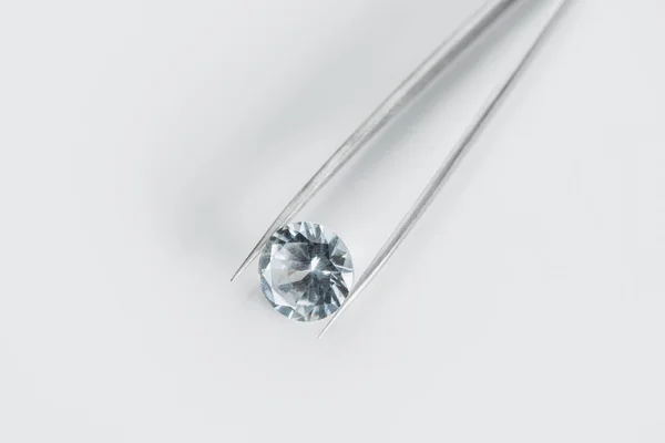 Vista superior de diamante brilhante em pinças sobre fundo branco — Fotografia de Stock
