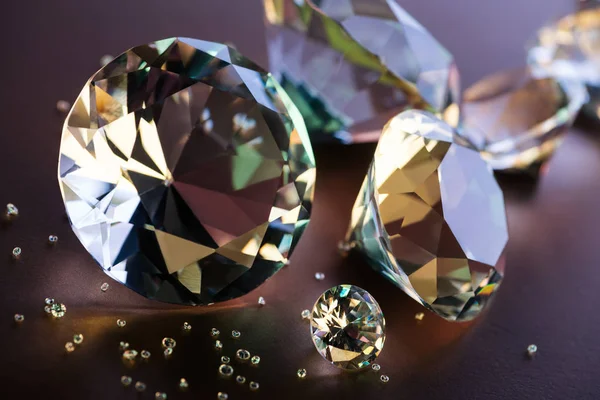 Gros plan de gros et petits diamants sur fond brun — Photo de stock